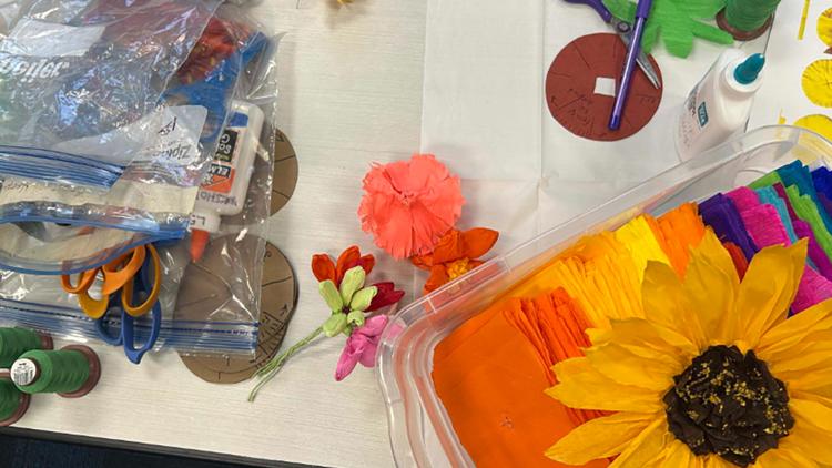 Families engaging in colorful Día de los Muertos crafts at a San Antonio Public Library event.